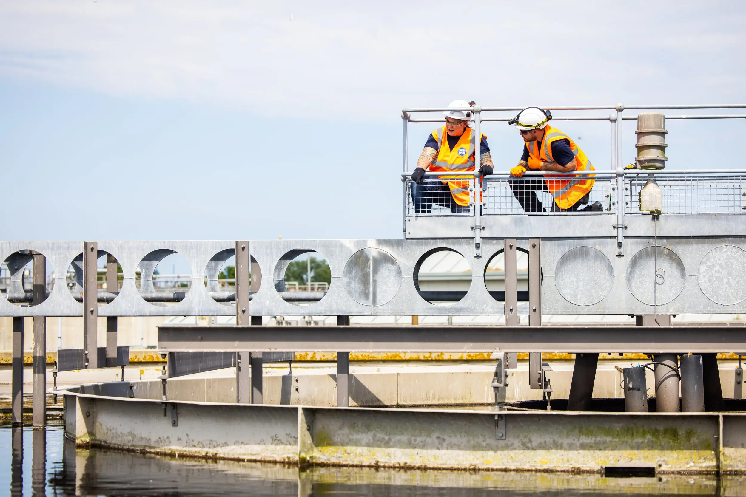 Two people working above a wastewater treatment tank