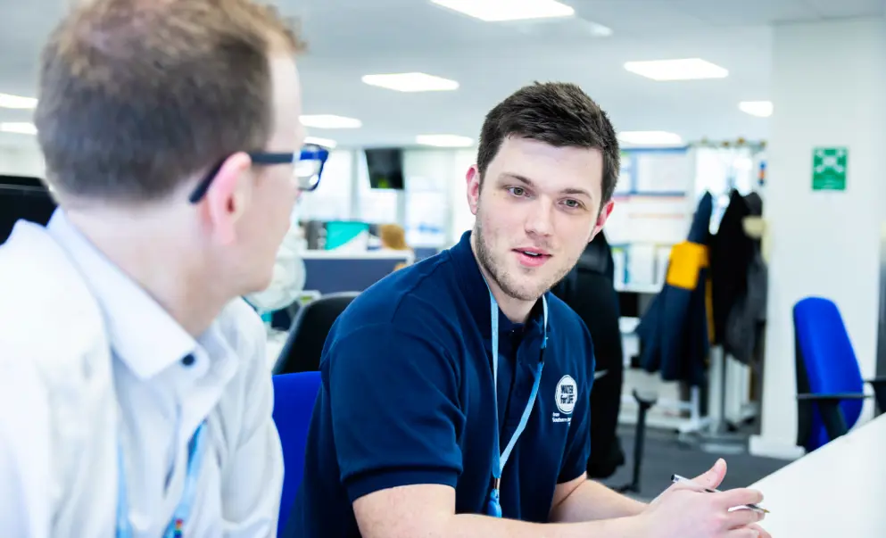 Two southern water employees conversing in the office