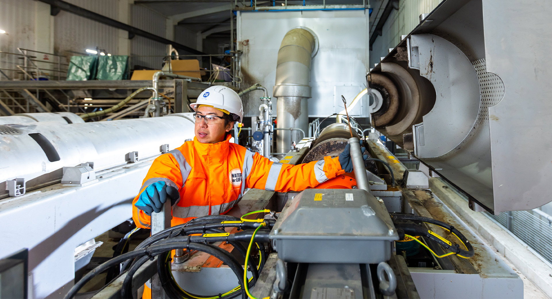 A photo of Ho Liam Yeung examining machinery