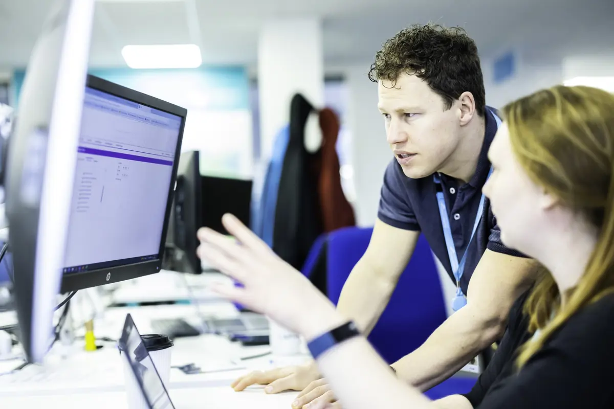 Two workers collaborating looking at a computer