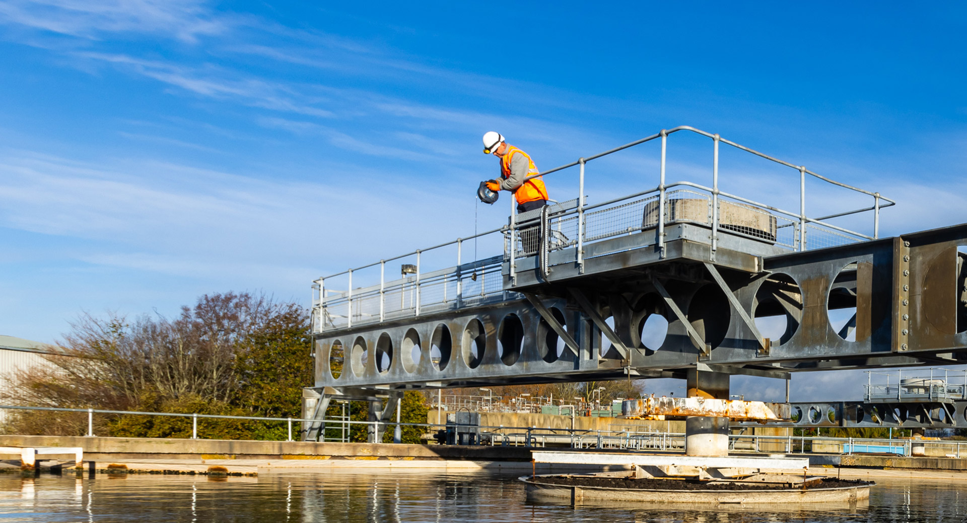 A photo of John Robertson working on a platform pertruding above a body of water
                        