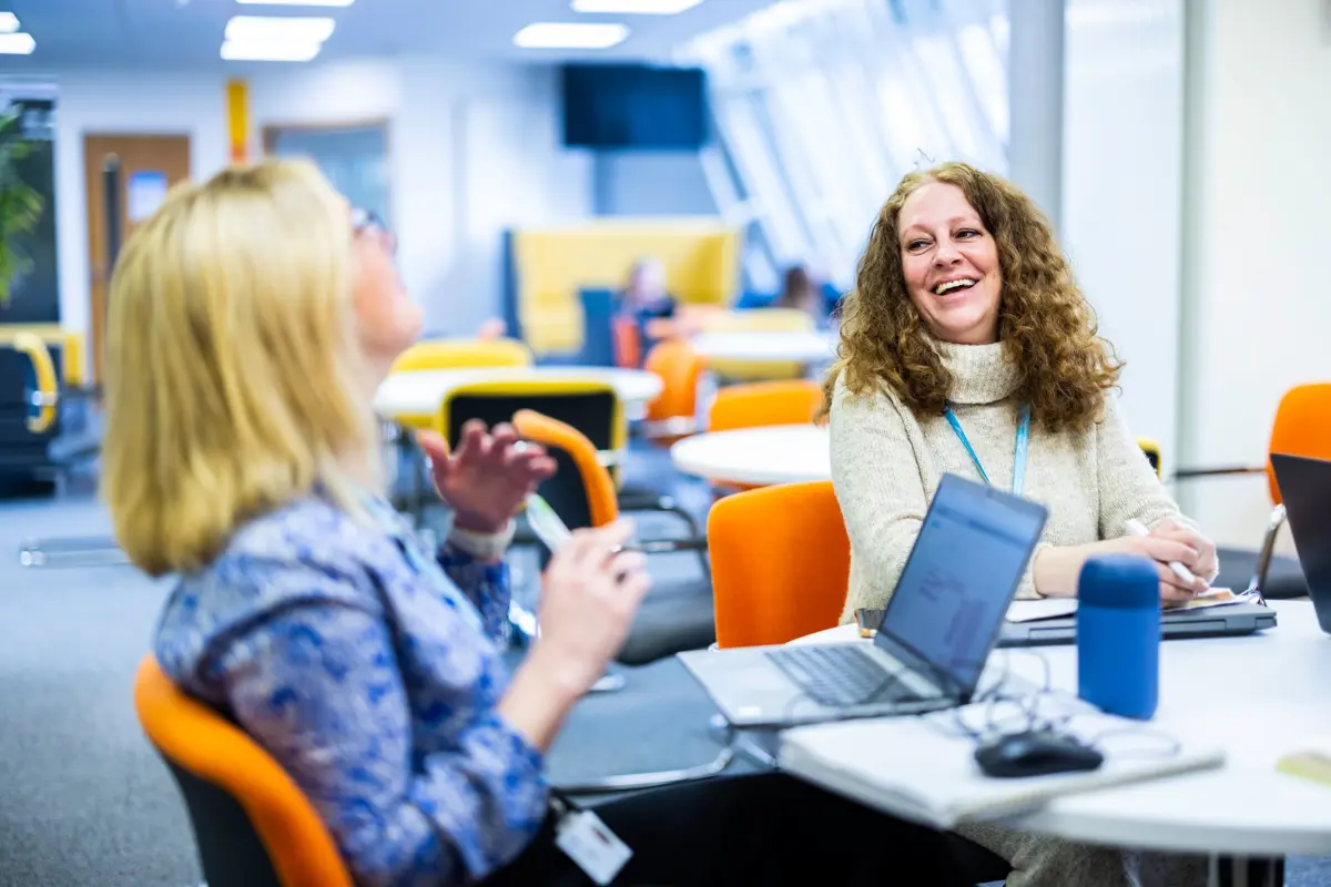 two ladies enjoying work in an office